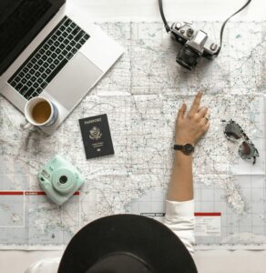 Overhead photo of a woman wearing a hat pointing at a map to demonstrate 8 strategic tips for taking time off as a solopreneur